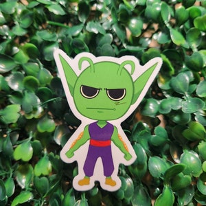 Könnte beinhalten: Ein Aufkleber mit einem grünen Alien-Charakter in einem lila und roten Outfit. Das Alien hat einen ernsten Ausdruck mit zusammengezogenen Augenbrauen und einem Stirnrunzeln.
