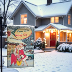 May include: A winter-themed garden flag with the text "Keep Calm and Merry On" in a retro style. The flag features a vintage illustration of a couple in festive attire, with a snowy backdrop and a house decorated for the holidays.
