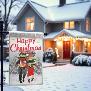 May include: A festive garden flag with the text "Happy Christmas" in red. The flag depicts an illustration of two figures laden with gifts, traversing a snowy bridge. A snow-covered house forms the backdrop, evoking a winter scene.