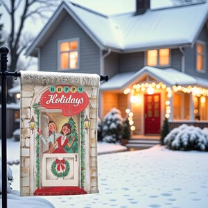 May include: A festive outdoor flag with a retro illustration of a couple at a doorway. The flag displays the text "Happy Holidays" in red and teal, set against a snowy house with Christmas lights.