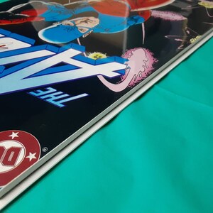 May include: A close-up of the spine of a comic book with a blue and black cover. The title "The New Gods" is printed in white on the cover. The DC Comics logo is visible in the lower left corner.
