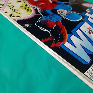May include: A comic book cover featuring a blue and red superhero with a mask and cape. The cover is titled "WOLF" with a large atom symbol in the background.