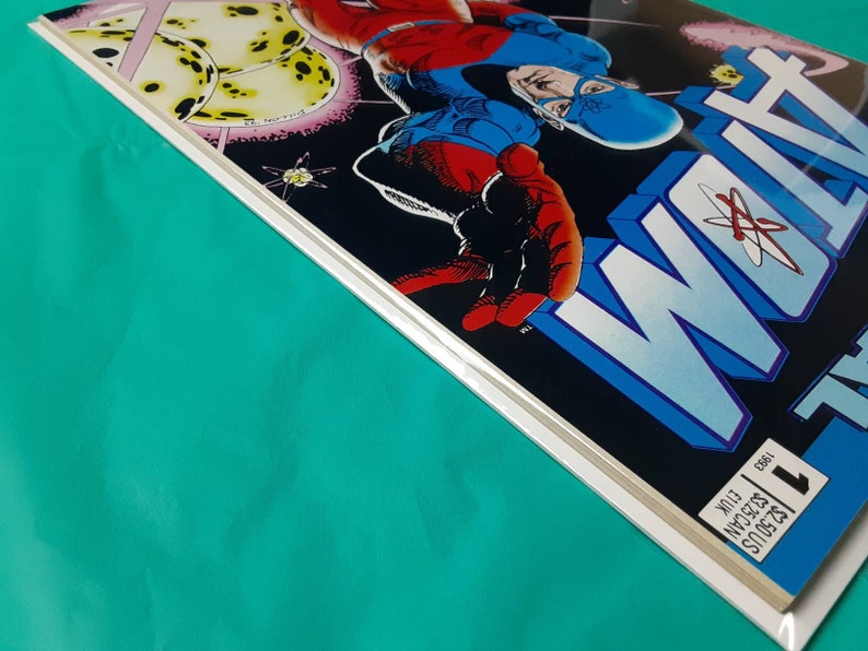 May include: A comic book cover featuring a blue and red superhero with a mask and cape. The cover is titled "WOLF" with a large atom symbol in the background.