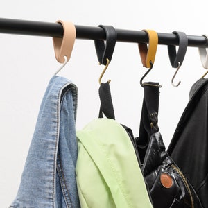 leather S-Hook, lifestyle photo, clothes and backpacks hanging from coat hooks on a black rod
