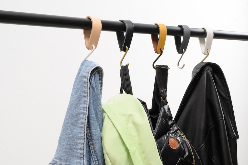 leather S-Hook, lifestyle photo, clothes and backpacks hanging from coat hooks on a black rod