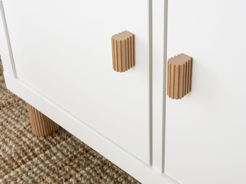Ribbed beech wood handles installed on kitchen cabinets Scandinavian minimalist interior design