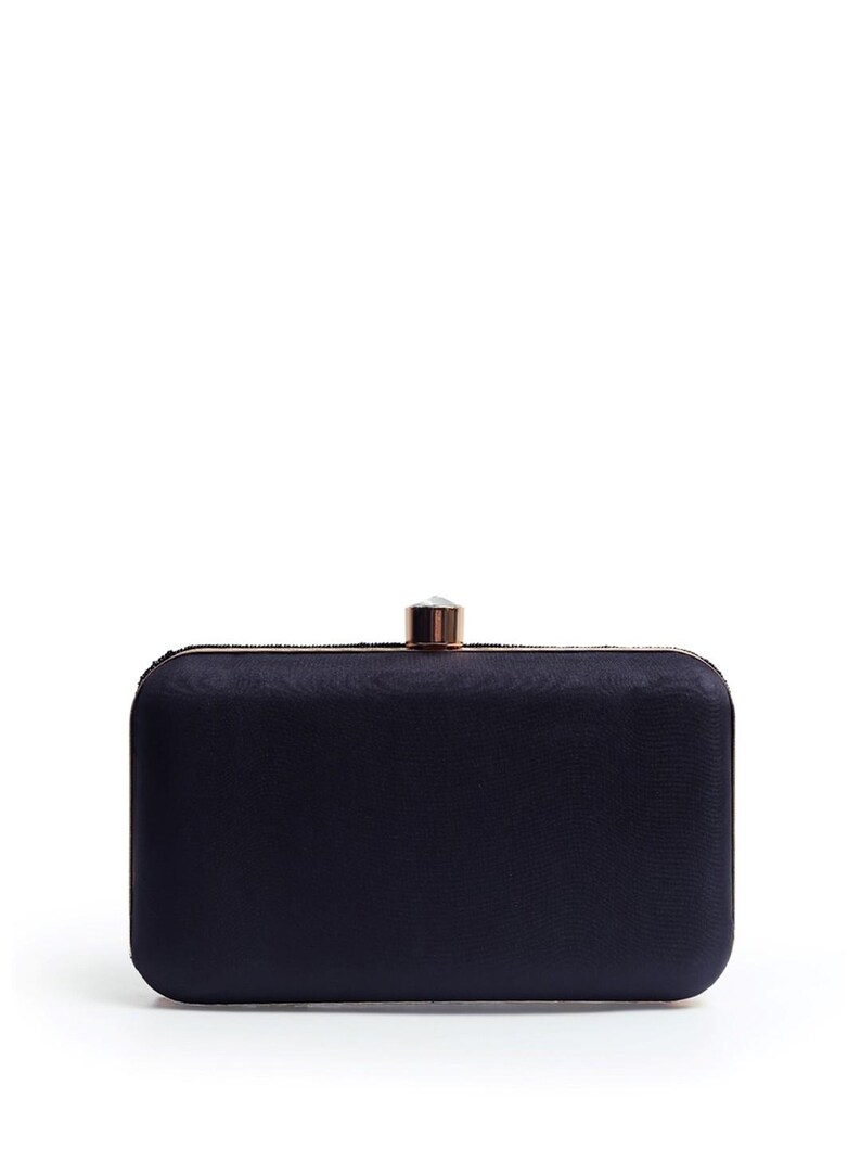 Puede incluir: Un clutch de sat&eacute;n negro con cierre de oro rosa y un adorno de cristal transparente.