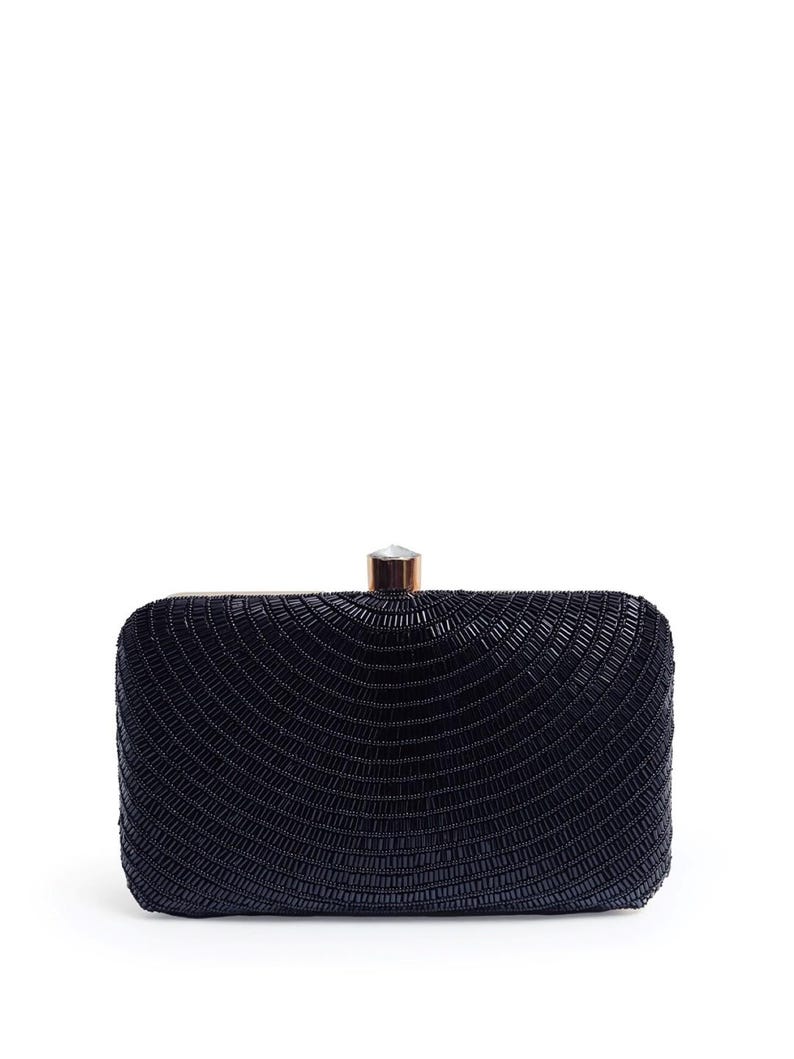 Puede incluir: Un clutch negro de cuentas con cierre dorado.