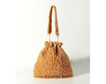 May include: A gold beaded bucket bag with a drawstring closure and a long strap.
