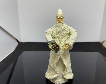 Papá Noel antiguo hecho de papel maché en la copa del árbol