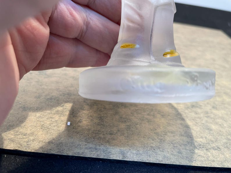 Puede incluir: Una figurita de vidrio transparente de una persona con sombrero y botas. La figurita est&aacute; de pie sobre una base de vidrio transparente con las palabras "Baccarat France" inscritas en la parte inferior.
