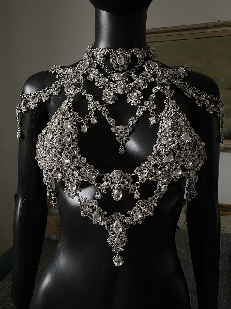 Puede incluir: Una cadena de cuerpo plateada de varios niveles, adornada con cristales y un colgante. La cadena presenta un dise&ntilde;o delicado y ornamentado, perfecto para a&ntilde;adir un toque de brillo a cualquier atuendo.