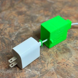 May include: A white wall adapter with a green protective cover attached to a white USB-C cable.