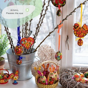 May include: A collection of colorful, hand-painted Easter eggs, some in the shape of hearts and chickens, with a text overlay that reads "Artistic, Please the eye".