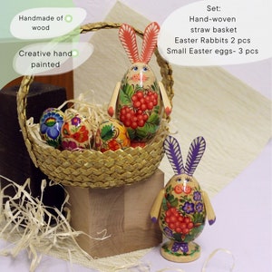 May include: Hand-painted wooden Easter bunny figurines with floral designs, a straw basket, and three small painted eggs. The set includes two bunnies and is handmade of wood.