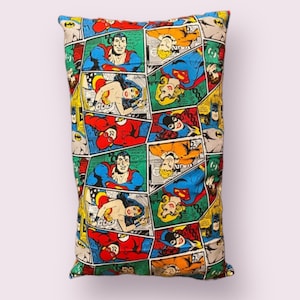 May include: A colorful pillowcase featuring a comic book pattern of superheroes and villains. The pattern includes Superman, Wonder Woman, Batman, and The Flash. The pillowcase is made of a soft, durable fabric and is perfect for adding a touch of fun to any bedroom.