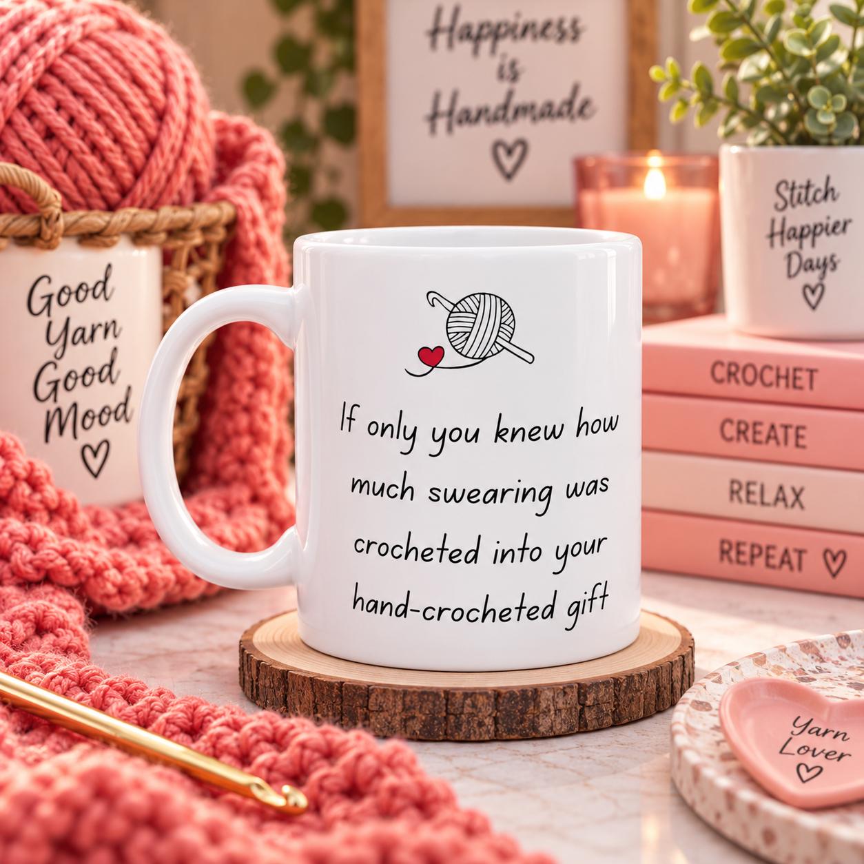 May include: A white ceramic mug featuring a black graphic of a yarn ball and crochet hook with a small red heart. The text reads: If only you knew how much swearing was crocheted into your hand-crocheted gift. The mug sits on a round wood coaster.