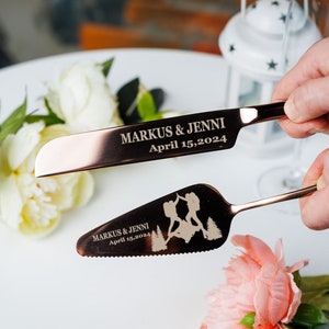 Puede incluir: Juego de cuchillos para cortar pastel de oro rosa con una silueta de montaña y el texto "Markus & Jenni April 15, 2024".