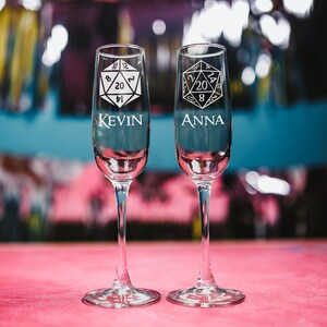 May include: Two champagne flutes with a 20-sided die design and the names "Kevin" and "Anna" etched on them.