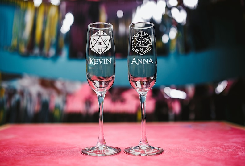 May include: Two champagne flutes with a 20-sided die design and the names "Kevin" and "Anna" etched on them.