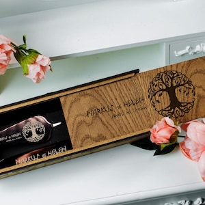 May include: A wooden box with a hinged lid, engraved with the text "Markus & Helen" and a tree of life design. The box contains a small, engraved metal tool.