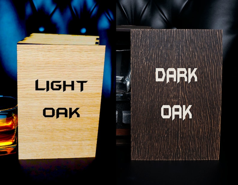 May include: Two wooden boxes with the words "LIGHT OAK" and "DARK OAK" engraved on them. The boxes are closed and sitting on a black surface.