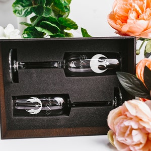 May include: Two champagne flutes in a brown box with a black interior. The flutes are engraved with the Rebel Alliance symbol and the word "Rebel".