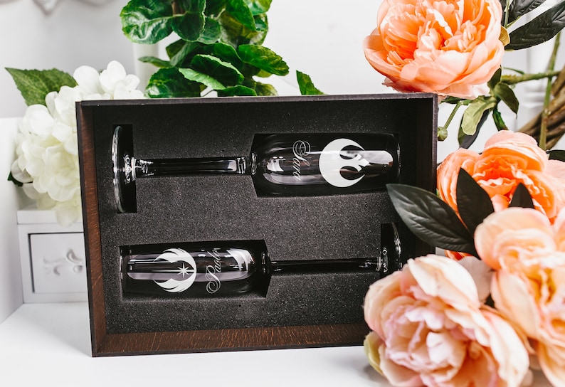 May include: Two champagne flutes in a brown box with a black interior. The flutes are engraved with the Rebel Alliance symbol and the word "Rebel".