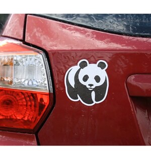 May include: A red car with a black and white panda sticker on the back.