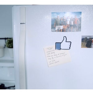 May include: A white refrigerator with a blue thumbs up magnet, a handwritten note, and two photos. The note says "To Do: Groceries, Call Jenny, Pick up story at Kroger, Say hi to Jeremy & Tyler, See you, Have a great day!"