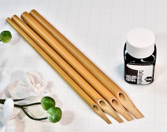 May include: Four bamboo calligraphy pens with a bottle of black calligraphy ink. The ink bottle has a white lid and a label that says "Calligraphy Ink".