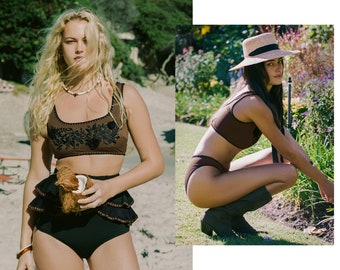 May include: Two women wearing different styles of brown and black bikini tops and bottoms. One woman is holding a coconut and the other is wearing a straw hat and boots.