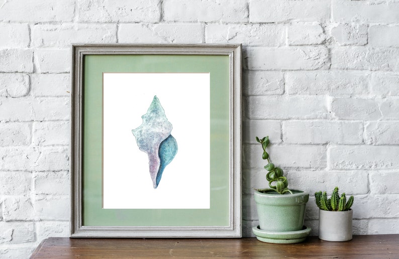 May include: A watercolor painting of a seashell in shades of blue, purple, and white. The seashell is framed in a light green frame.