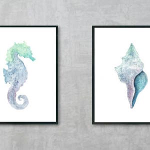 May include: Two framed watercolor paintings of sea life. The first painting features a blue and green watercolor seahorse. The second painting features a blue and purple watercolor seashell.