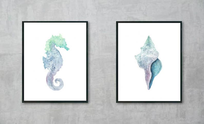 May include: Two framed watercolor paintings of sea life. The first painting features a blue and green watercolor seahorse. The second painting features a blue and purple watercolor seashell.