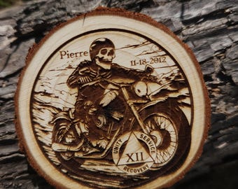 May include: A wooden circle with a burned image of a skeleton riding a motorcycle. The circle has the text "Pierre 11-18-2012" and a 12-step triangle with the words "Unity, Service, Recovery" and the number "XII".