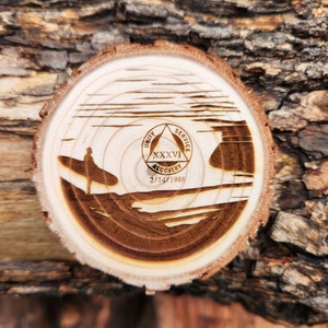 May include: A wooden circle with a design of a surfer riding a wave. The circle has a triangle with the words "Unity, Service, Recovery" and the number "XXXVI" inside. The date "2/14/1988" is also included.