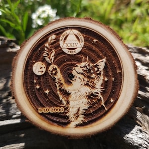 Pode incluir: Um círculo de madeira com um desenho de gato, um triângulo com as palavras "Happy, Joyous, Free" e o número "XXIV" dentro, e a data "8-10-2000".