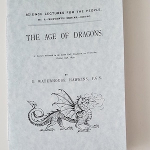 May include: A vintage pamphlet titled "THE AGE OF DRAGONS" with text and a detailed illustration of a dragon. The pamphlet is light blue with black text and a dragon illustration. The text includes "SCIENCE LECTURES FOR THE PEOPLE" and the author's name.