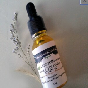 Puede incluir: Un peque&ntilde;o frasco de vidrio &aacute;mbar con un gotero negro. La etiqueta es blanca con texto negro que dice "EARTHEN URBAN ESSENTIALS Organic Ayurvedic HELICHRYSUM REGEN-10 Intensive Skin Renewal/Repairing Serum .5oz".