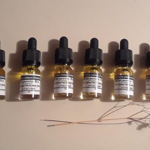 Pode incluir: Seis pequenos frascos de vidro com conta-gotas cheios de um l&iacute;quido amarelo. Os frascos s&atilde;o etiquetados com "Turmeric Rx" e "Green Urban Essentials".