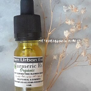 Pode incluir: Um pequeno frasco de vidro &acirc;mbar com um conta-gotas preto. O frasco &eacute; etiquetado com "Turmeric Rx Organic Spot Correcting Blemish Serum Helps Heal & Diminish Pimples-Eczema-Redness 10ML".