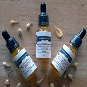 Puede incluir: Tres botellas de vidrio &aacute;mbar con goteros azules y etiquetas blancas. Las etiquetas tienen el texto "Ayurvedic, Helichrysum Regen-10, Suero Clarificante y Rejuvenecedor Intensivo para la Piel".