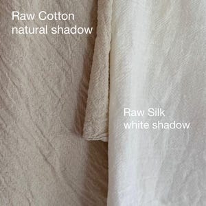 Puede incluir: Una comparaci&oacute;n lado a lado de dos telas con una superficie texturizada y arrugada. La tela de la izquierda es beige con el texto 'Raw Cotton natural shadow'. La tela de la derecha es blanca con el texto 'Raw Silk white shadow'.