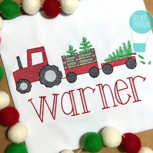 Puede incluir: Tractor de juguete rojo tirando de un vag&oacute;n lleno de &aacute;rboles de Navidad verdes con el nombre "Warner" bordado en blanco con contorno rojo sobre un fondo blanco.