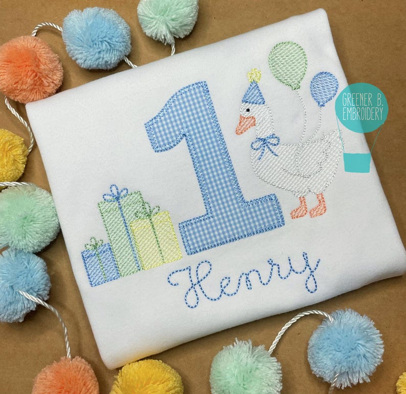 May include: A white onesie with blue and white gingham number one, a white goose with a party hat, and presents. The onesie is personalized with the name "Henry".