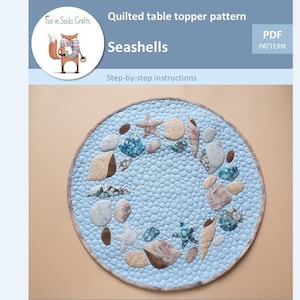 Może przedstawiać: Wzór PDF na pikowany obrus z motywem muszli. Obrus jest okrągły i ma jasnoniebieskie tło z brązowymi, białymi i niebieskimi muszlami i gwiazdami morskimi.