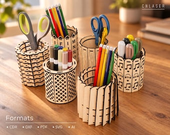 May include: Five cylindrical wooden pencil holders with laser-cut designs including letters, lattice patterns, vertical slats, and musical notes. The holders contain various colored pencils, markers, and scissors. Text includes CNLASER and Formats CDR, DXF, PDF, SVG, AI.