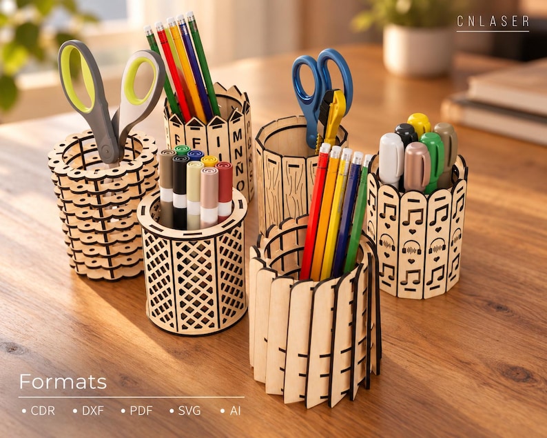 May include: Five cylindrical wooden pencil holders with laser-cut designs including letters, lattice patterns, vertical slats, and musical notes. The holders contain various colored pencils, markers, and scissors. Text includes CNLASER and Formats CDR, DXF, PDF, SVG, AI.