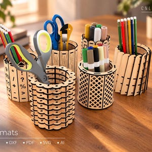 May include: A collection of four cylindrical wooden pencil holders with laser-cut designs, including one with mathematical symbols and numbers, filled with various colored pencils, markers, and scissors. The text CNLASER and Formats CDR DXF PDF SVG AI are visible.